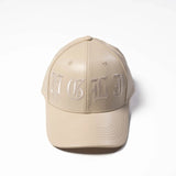 Beige cap with 'MGLJ' embroidery on a white background